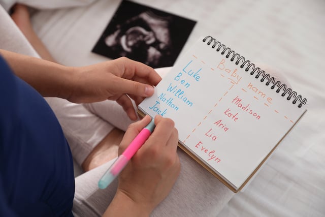 Une femme enceinte en train de faire une liste de prénoms