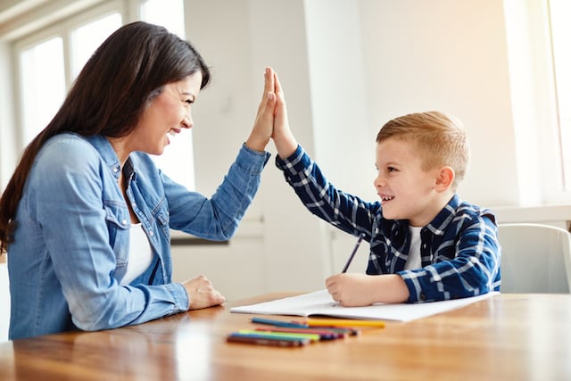 Une mère qui aide son fils à faire ses devoirs