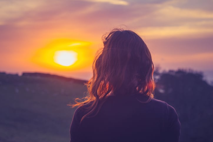 Une personne admire le lever du soleil