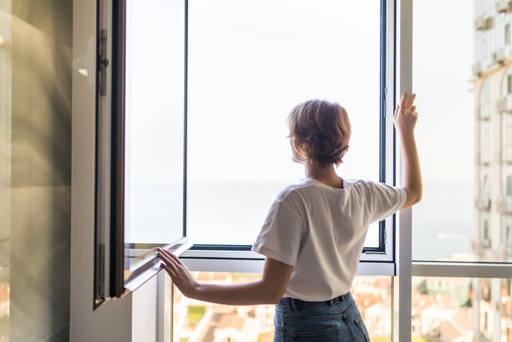 Une femme ouvre la fenêtre