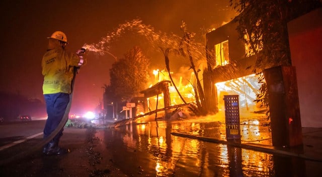 Un pompier utilisant de l'eau pour éteindre les feux dans une maison