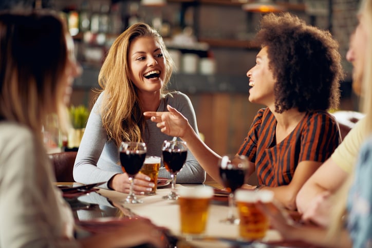 Des femmes boivent du vin à table