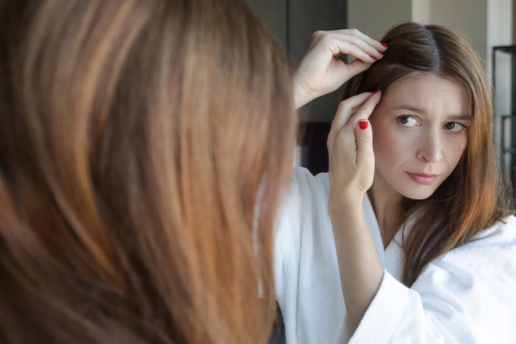 Une femme observe ses cheveux