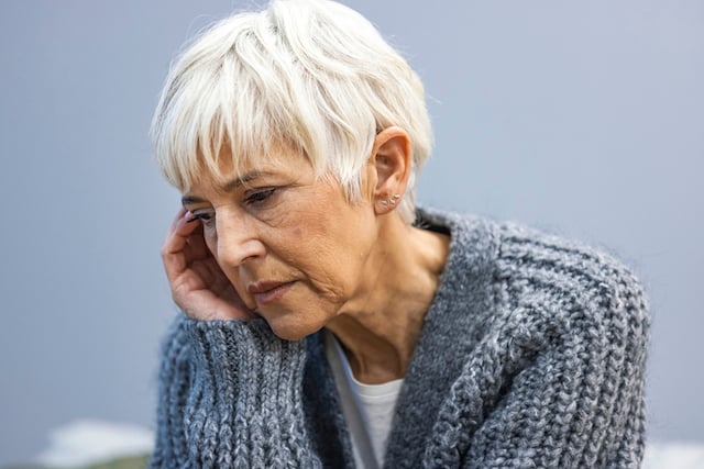 Une femme âgée de 60 ans perdue dans ses pensées 