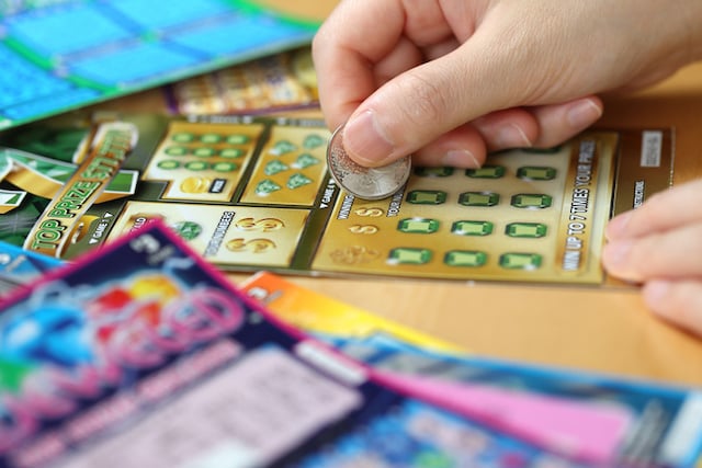 Une femme en train de gratter un ticket 