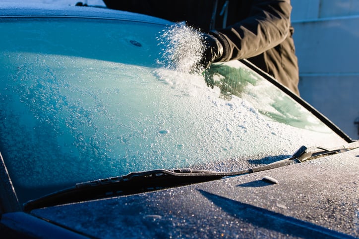 Une personne retire le gel de sa voiture