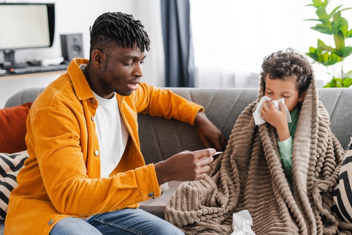 Un homme prend la température de son enfant malade