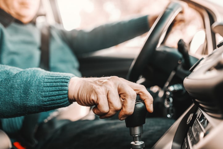 Une personne âgée passe une vitesse