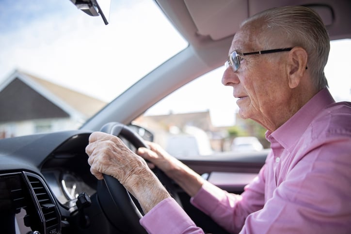 Un homme âgé en train de conduire