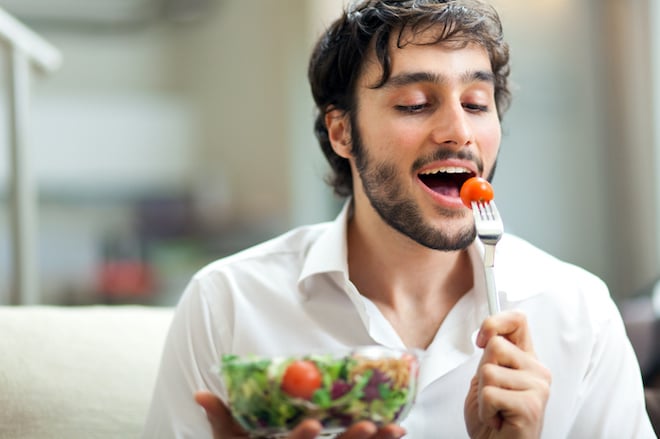 Un homme en train de manger une salade