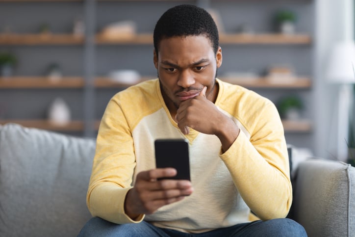 Un homme réfléchit devant son smartphone