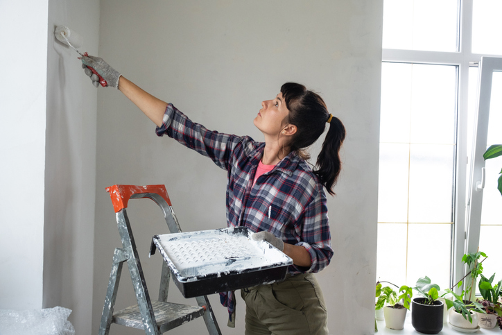 Une femme peint un mur