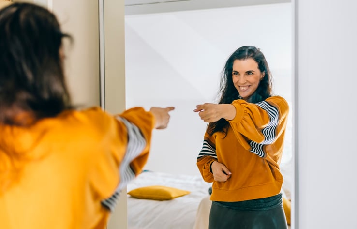 Une femme heureuse devant son miroir