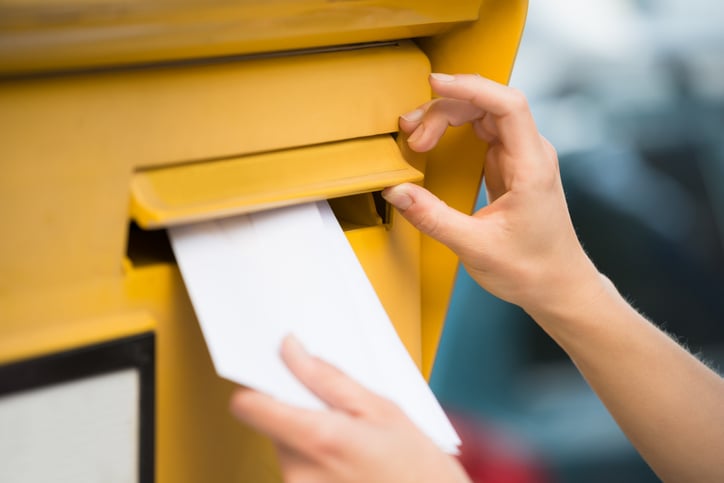 Une femme dépose un courrier