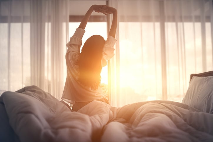 Une femme s'étire sur son lit