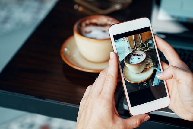 Une personne en train de photographier sa tasse de chocolat