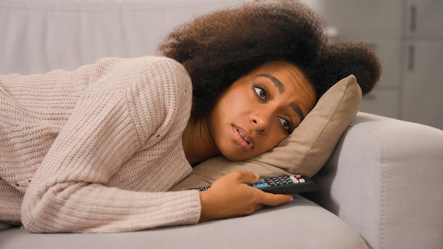 Une femme qui regarde la télévision depuis son canapé