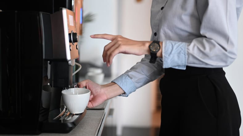 Une employée se sert un café