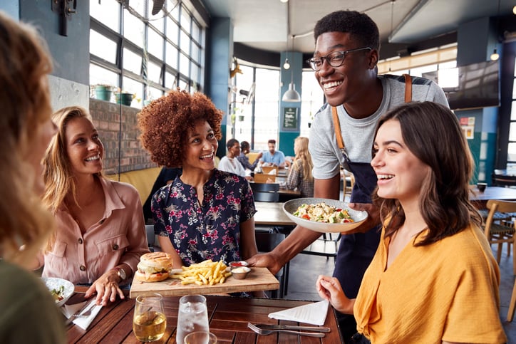 Un serveur et des clients souriants