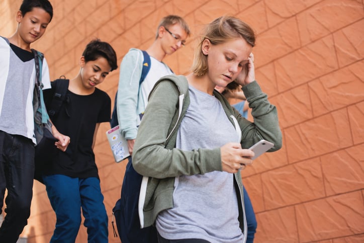 Une adolescente regarde son téléphone