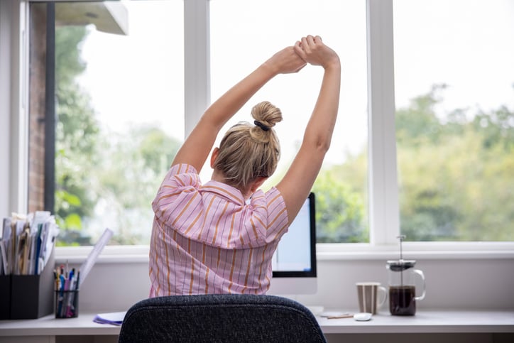 Une femme s'étire en travaillant