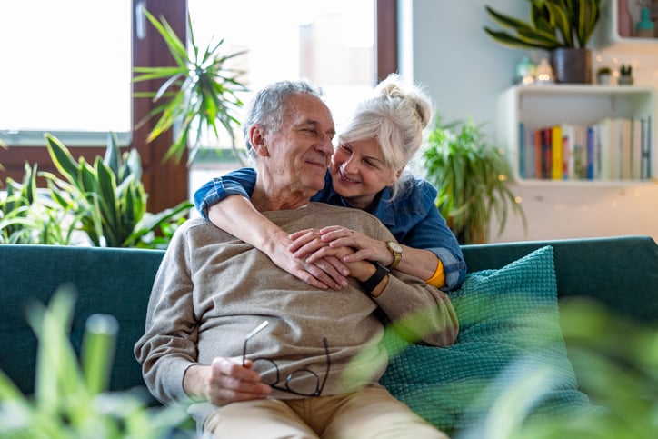 Un couple de seniors savoure un moment de tendresse sur le canapé