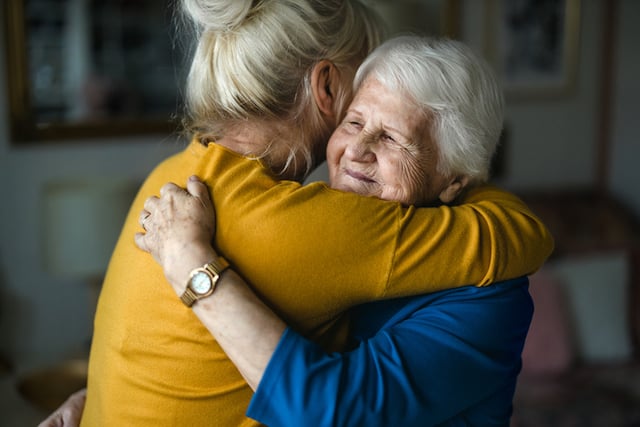 Une grand-mère qui enlace une femme adulte 