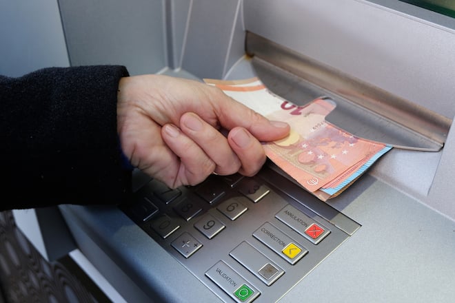 Un homme retire de l'argent à la banque