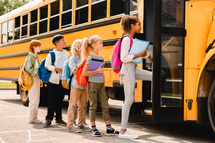 Des enfants montent dans un bus scolaire