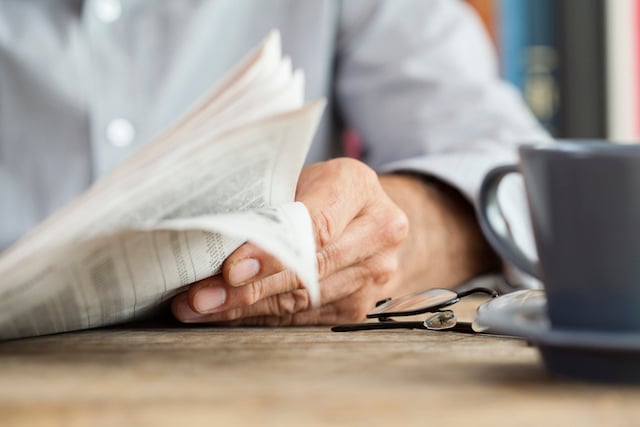 Un homme en train de lire le journal 