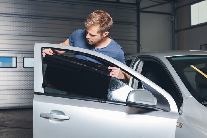 Un homme pose des vitres teintées sur sa voiture