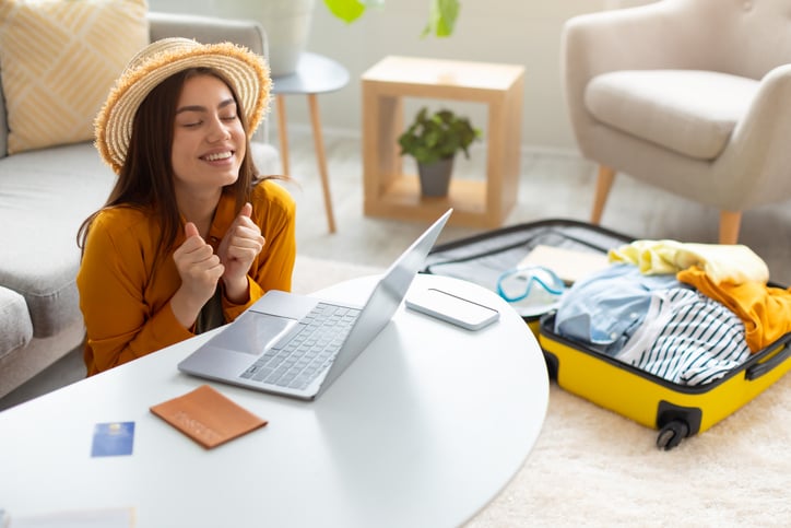 Une femme heureuse d'avoir réservé sa location de vacances sur internet