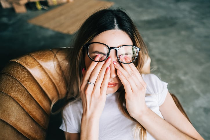 Une femme fatiguée se frotte les yeux