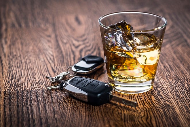 des clés de voiture à côté d'un verre d'alcool