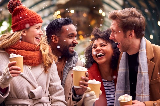 Amis partageant un chocolat chaud sous la neige