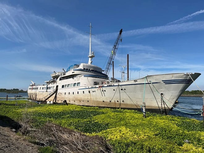 bateau rénové devant un parterre de fleurs