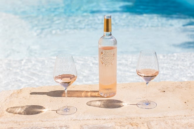 bouteille de vin rosé Ultimate Rosé et deux verres à côté d'une piscine