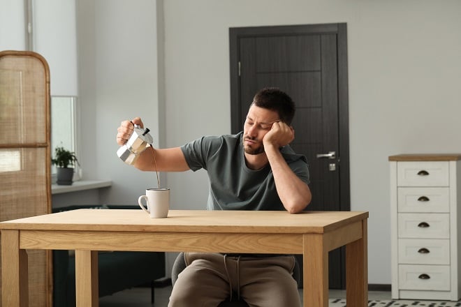 homme endormi versant du café dans une tasse