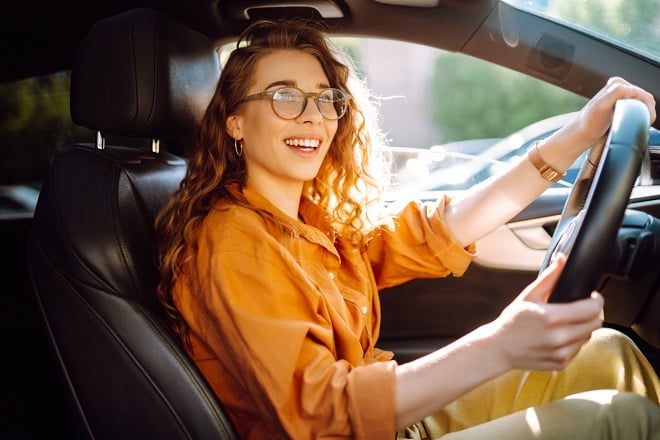 Jeune conductrice souriante en voiture