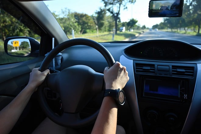 Conducteur les mains sur le volant à l'intérieur d'une voiture