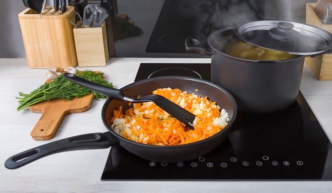 Poêle avec des légumes en train de cuire avec une spatule