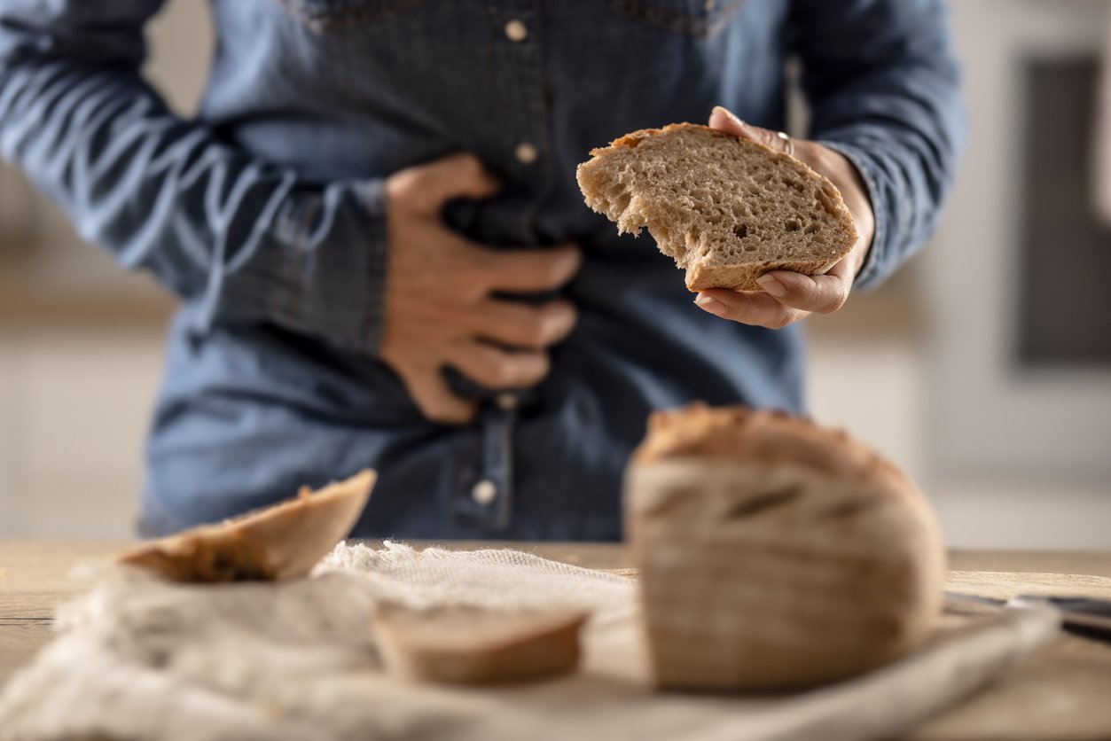 personne intolérante au gluten mangeant du pain