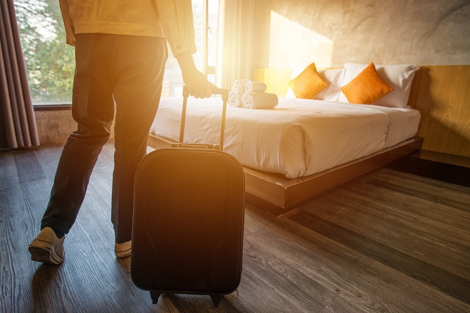 un touriste traînant sa valise dans sa chambre d'hôtel