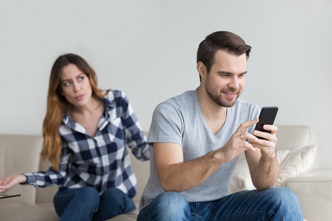 femme suspectant son mari de discuter avec une autre sur son téléphone