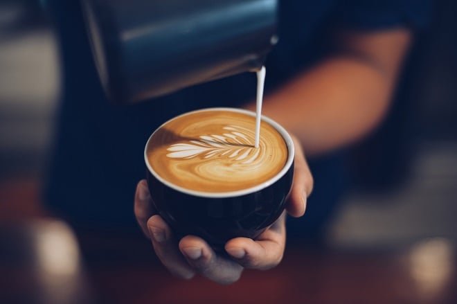 Barista faisant un latte art dans une tasse