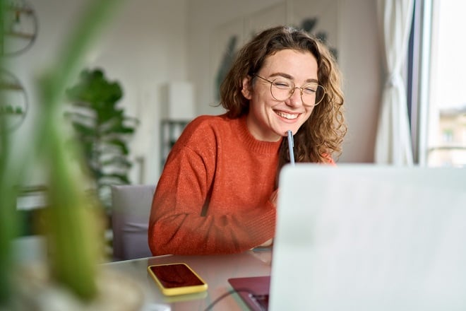 Jeune étudiante heureuse devant son ordinateur