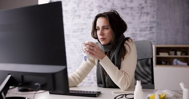 Jeune femme ayant froid au bureau