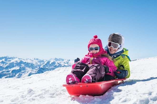 Mère et fille faisant de la luge à la montagne