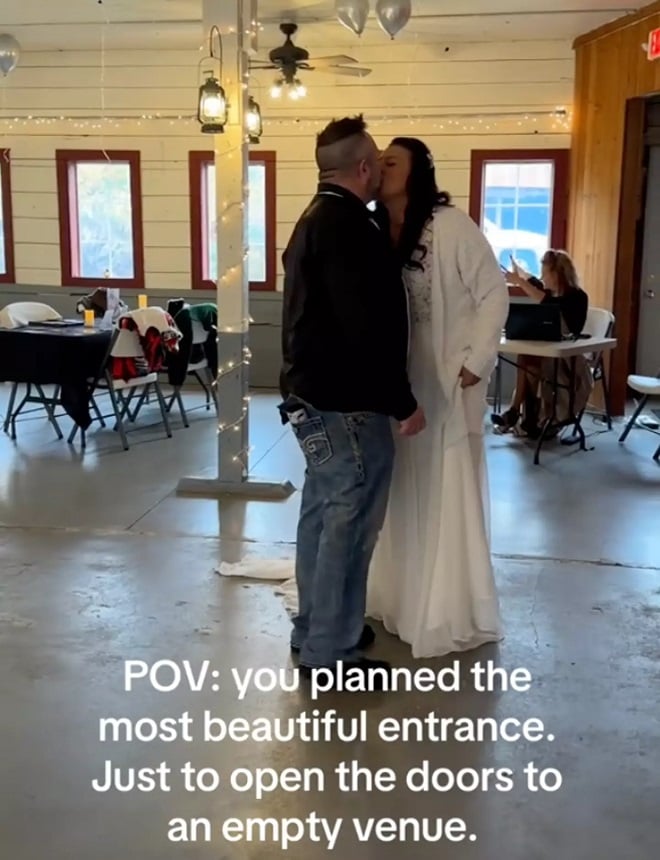 le couple s'embrassant le jour de son mariage dans une salle vide