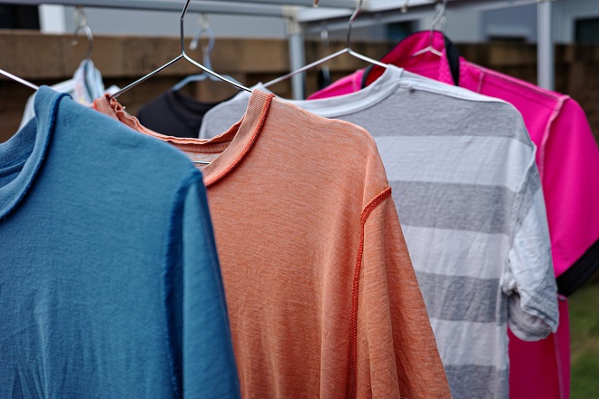 t-shirts sur des porte-manteaux étendus sur un fil à linge